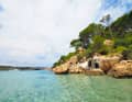 In the twin bay of Cala Algaiaren, a kind of tiny house is wedged between the rocks.