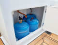 The regulator and the remote control solenoid valve are located in the gas locker. The orange sticker indicates a 50 millibar system and the line leads from the gas box to the outside via a bulkhead fitting.