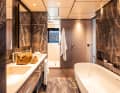 The wellness oasis itself extends across the entire width of the bow. There is a bathtub and double washbasin in the centre, with a shower and WC on either side