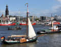 Traditional sailing ship in front of the panorama of the Landungsbrücken with the Michel in the background