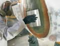 Adhesive: Precisely dosed and well mixed, an adhesive resin is applied to the old mirror plate cut-out using a wide spatula