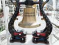 The ship's bell on the forecastle of the full-rigged ship.
