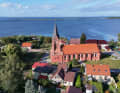 Blick auf die Kirche von Nowe Warpno mit dem Haff dahinter.