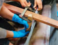 Once the screws are tight, the stringers are brought into perfect (hull) shape using a batten frame and screw clamps