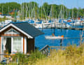 The wide round harbour of Klagshamn almost looks like a natural bay. The southern shore is lined with tiny holiday cottages