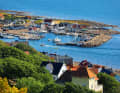 View from the wooded heights of the Kullaberg down to the harbour of Mölle. It is early afternoon. Those who arrive in the evening can look forward to a place in the packet