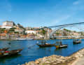 Nachbildungen der typischen „Rabelos“ auf dem Douro vor der Brücke Luís I. und der Kulisse der Stadt Porto