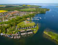 Blick vom Röbeler Binnensee über Bootshäuser und die Stege der Marina Röbel mit der Müritz im Hintergrund