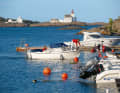 Local boats in front of the Lyngør Fyr lighthouse
