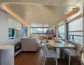 The bright lounge is opened up by the galley and dining area opposite.