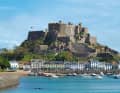 Jerseys älteste Burg Mont Orgueil Castle (um 1200 gebaut) mit dem Ort Gorey zu Füßen – eine beinahe mediterrane Postkartenidylle. Das Foto ist bei Hochwasser aufgenommen, bei Niedrigwasser fällt der Hafen vollständig trocken