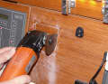 Roughly mask off the outline and mark the exact dimensions with the template. We created the cut-out using a vibration saw