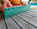 A sanding board with 40-grit paper is used to create as flat a surface as possible. An eccentric sanding machine would easily sand waves into the deck, so it is better to work by hand