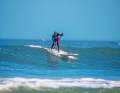 SURF-STANCE   Die etwas elegantere Form des Anpaddelns im Surf-Stance (ein Fuß vor dem anderen) fordert eine bessere Balance. Der Vorteil: Man muss nicht mehr in diese Position springen, um die Welle abzureiten. Wie bei der parallelen Fußtechnik die Welle energisch anpaddeln (Bild 1).
