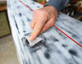 3. first layer of glass fibre: Cut a small triangle the size of the repair area out of a glass fibre mat and place the piece of glass fibre on the break.
