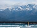 In der Bucht von Calvi surft man mit Blick auf die imposante Kulisse Korsikas. Die Berge rund um den über 2700 Meter hohen Monte Cinto sind im Frühjahr oft noch vom Schnee bedeckt.