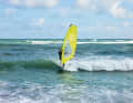 Position yourself at a safe distance on a wave that is building up and surf with it towards the beach