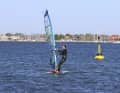 Das Board beginnt durch das Anluven gegen den Wind zu drehen. Setze rechtzeitig den vorderen Fuß nach vorne vor den Mast. Der hintere Fuß bleibt an Ort und Stelle stehen, kann sich zum bequemeren Stehen lediglich etwas drehen.