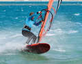 So instead of "Push the leeward edge with your back foot", the following tip would be more appropriate: "Let the sail pull you towards the inside of the turn." This tip basically contains all the decisive factors: In order for your sail to build up tension in the turn, it must be pulled tight - hence the wide grip on the boom in the preparation phase. By actively sheeting in and stretching the front arm at the same time, your sail builds up tension and brings your entire body to the inside of the turn, which automatically loads the leeward edge.