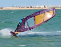 This causes the mast to fold to the inside of the bend. By pulling the sail over your head and to windward, you will be able to reach far forward on the new boom side.