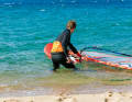 1 To start, set your board half-windward (crosswind) and grip the mast with your front hand directly above the boom.