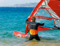 Now you want the sail over your head without the boom end getting stuck in the water. Therefore, pull the mast forwards over your head with your front hand.