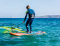 Bend your knees slightly, keep your back straight and pull the sail just a little way out of the water. The wind will now turn the sail like a flag with the wind to the leeward side...