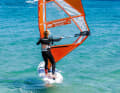 The jibe in windsurfing step by step: As always, get some momentum after the start and prepare for the jibe by moving the back hand on the boom slightly backwards towards the end of the boom.
