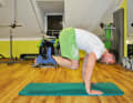 Then slowly pull your knees under your stomach so that your spine becomes rounded. You are also training your shoulder muscles here.