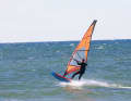 Get as much speed as possible, make sure your feet are firmly in contact with the loops and aim for a small ramp. Ideally, the wave should come from the front and you can hit it head-on on a half-wind course. You can also loop over the back of a wave, but because the wave runs away from you, you need more basic speed to avoid getting stuck on the take-off. A few seconds before take-off, push your sailing hand far back towards the clew and aim for the take-off.