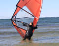 To generate enough power for the subsequent rotation, reach far back towards the clew with your sailing hand.