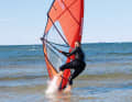 Push yourself slightly off the ground and pull in fully with your sailing hand. Look at your sailing hand as you do this, which will automatically turn your head backwards.