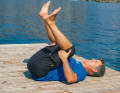 Lie flat on your back, lift your right leg first, grasp your thigh at the back of your knee, then your left leg. Pull both knees past your torso towards your armpit as far as you can, lifting your pelvis subtly off the floor. The long back extensor is stretched.