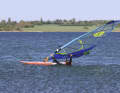 The first step is to grip the mast with the front hand, then the lower leech with the rear hand.