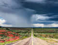 Eine dieser typisch schnurgeraden Straßen zieht sich durch die Ebene von New Mexico. Darüber wölbt sich ein imposanter Gewitterhimmel.