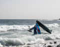 Walk carefully into deep water with the board on your shoulder