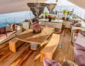 Under the awning: In the front, the large guest cockpit with dining table, two Murano candelabras hang from the main boom. It is directly connected to the galley below. The bronze sculpture in the centre of the table is by Cuban artist Roberto Fabelo