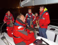 Männercrew auf Nachtfahrt. Es besteht Tragepflicht für Rettungswesten und -leinen