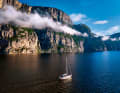 Ein schmales Wolkenband zieht entlang der Flanke einer steinernen Wand am Lysefjord. Davor die Yacht des Autors. Sie lässt die gewaltigen Dimensionen der Felsen erahnen