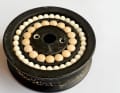 The structure is clearly visible on the open disc. The rollers run around a thick hub and absorb the compressive forces. The lateral balls guide the disc