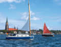 The fleet of cute boats against the backdrop of Schleswig's city centre with its cathedral and marina