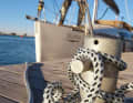 Mooring lines in use. The eyes of most prefabricated lines are designed for the cleats on board. They are too small to be placed over a bollard