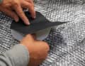 The damaged laminate sail is made of panels, the tear is quite large and lies next to a seam. Therefore, the mould is first fixed with transparent adhesive film, then glued with a patch made of stable, low-stretch Kevlar fabric