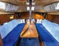 The saloon is cosy. When the table is lowered, you can sleep on a huge bed. Only the mast support remains in the way