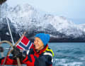 Andrea Barbera at the helm of the "Arctic Wisdom", a thermal sailing suit keeps him warm.