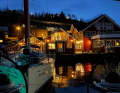 Evening atmosphere in the harbour of Lyngseidet, where the boats are moored in front of typical Scandinavian wooden houses.