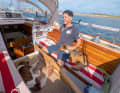 Owner Sven Klingenberg with on-board dogs in the cockpit of the "Chapina" as it enters Heiligenhafen. The invisibly installed autopilot does its work at the tiller.