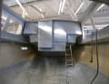 The empty hull is pushed into the hall before the boat builders start removing it.