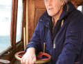 Hans-Christer Edborg at the helm of his "Svanevik". He has spent more than half a century on the historic Galiot.