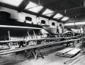 View of the shipyard's large construction hall in 1937, where cruisers and metre yachts of various sizes were being built at the same time. A specialised logman works on the mast.